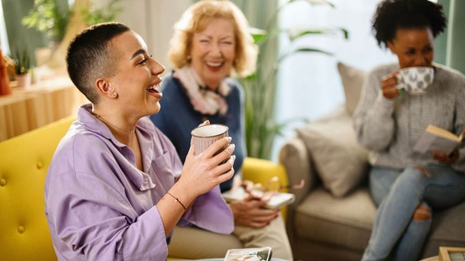 Three women enjoying their time and drinking coffee at book club in a modern home