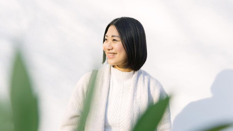 woman with dark hair smiling looking away from camera