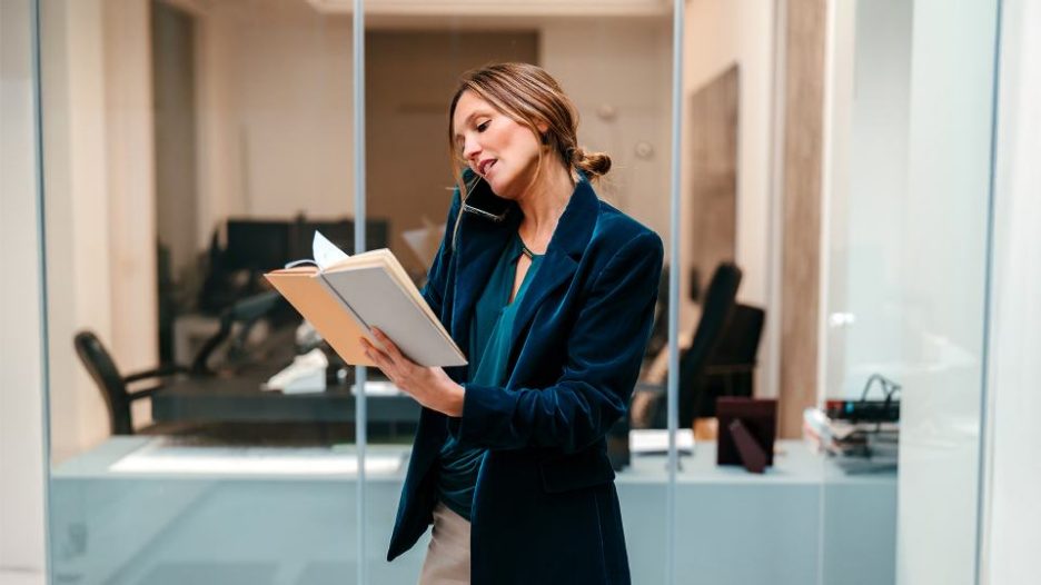 businesswoman checking diary while on a call