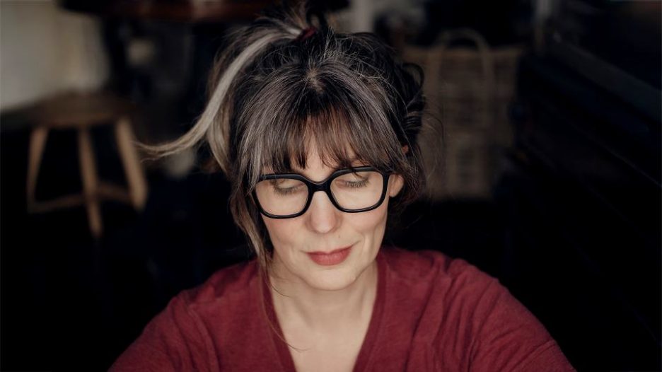 mid-aged woman with glasses looking down