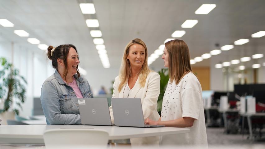 Female Aegon employees chatting at desk