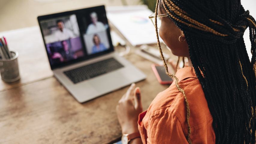 Female participating in group video call using laptop