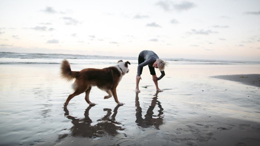 Vibrant mature woman enjoying herself on the beach at sunset