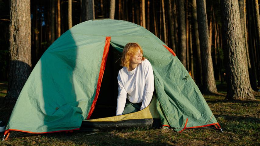 woman climbing out of a tent