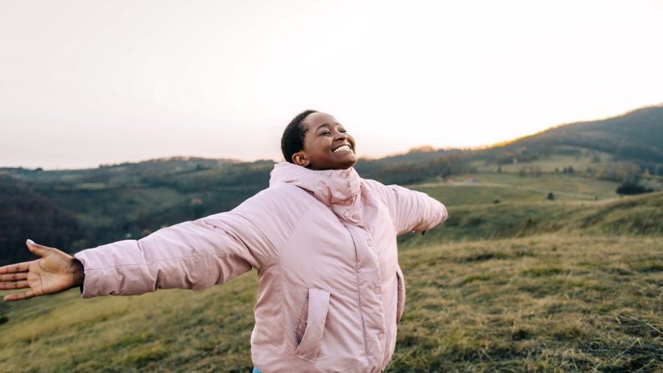 girl smiling with her arms out in the rural environment.