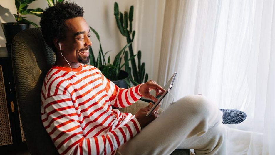 young man sitting at home and using digital tablet